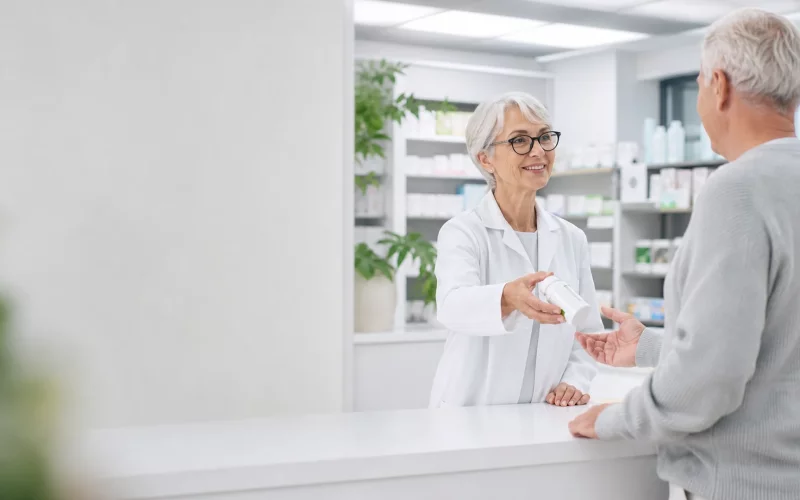 Pharmacien accompagnant un client pour préparer la vente de son officine